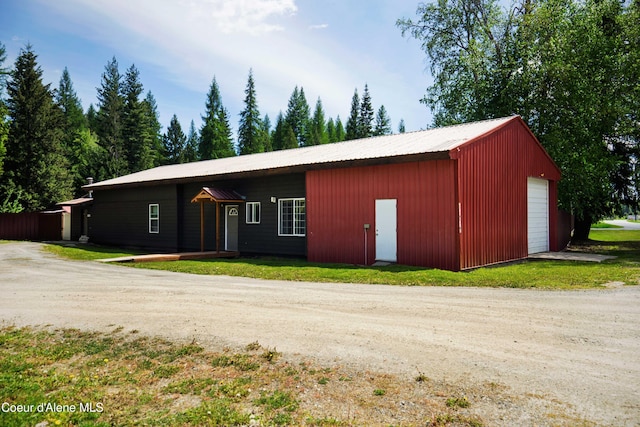 view of front of home featuring a front lawn, a garage, and an outbuilding