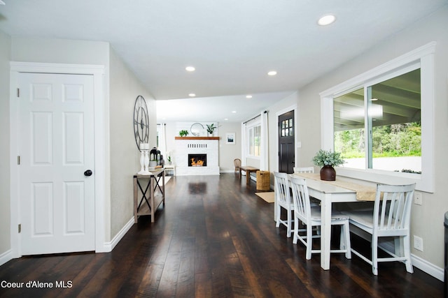 dining space featuring a fireplace and dark hardwood / wood-style floors