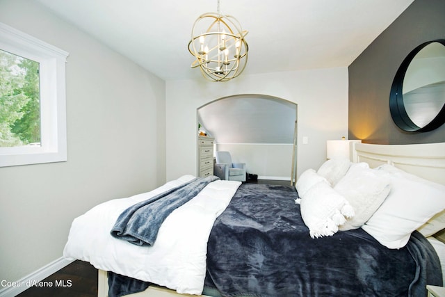 bedroom with a notable chandelier, dark wood-type flooring, and vaulted ceiling