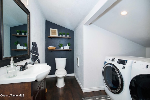 laundry area featuring sink, dark wood-type flooring, and separate washer and dryer