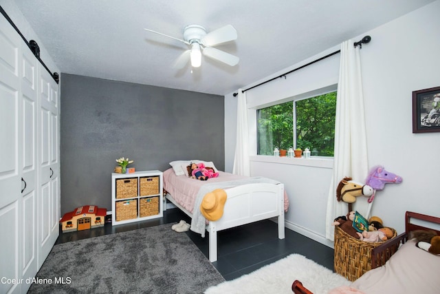bedroom featuring a closet, ceiling fan, and a barn door