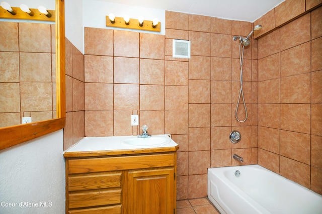 bathroom featuring tile patterned floors, tile walls, vanity, and tiled shower / bath
