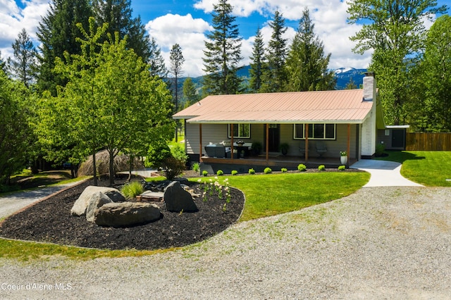 ranch-style house featuring a mountain view, covered porch, and a front yard