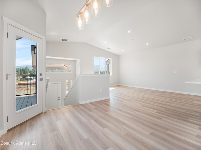 interior space featuring an inviting chandelier, vaulted ceiling, and light wood-type flooring