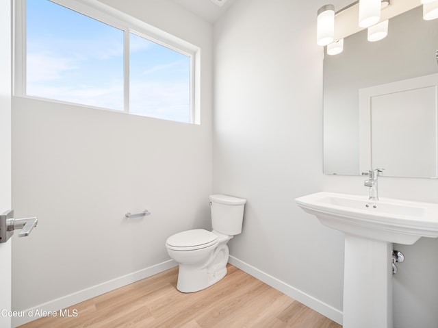 bathroom with sink, toilet, and hardwood / wood-style floors