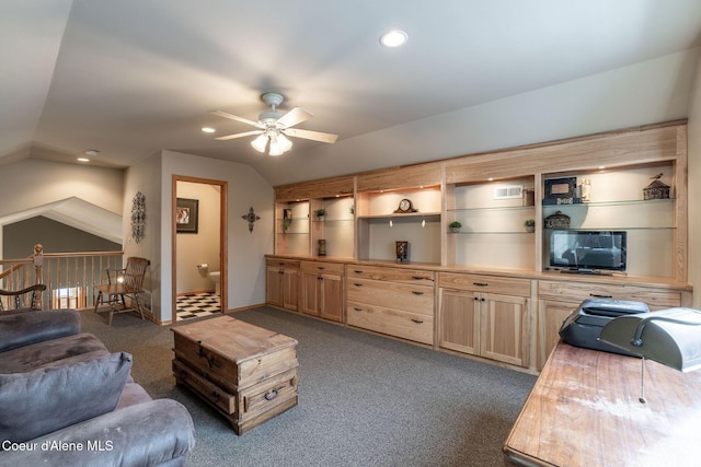 living room with ceiling fan, lofted ceiling, and dark carpet