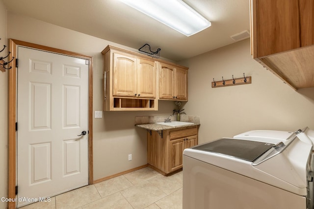 laundry room with light tile patterned flooring, cabinets, sink, and washer and dryer