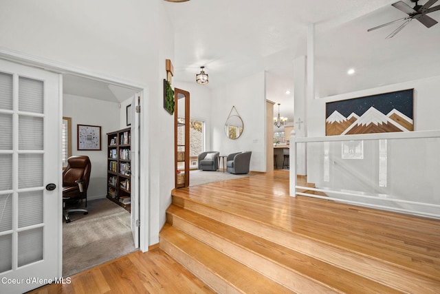 entrance foyer with wood-type flooring and ceiling fan with notable chandelier