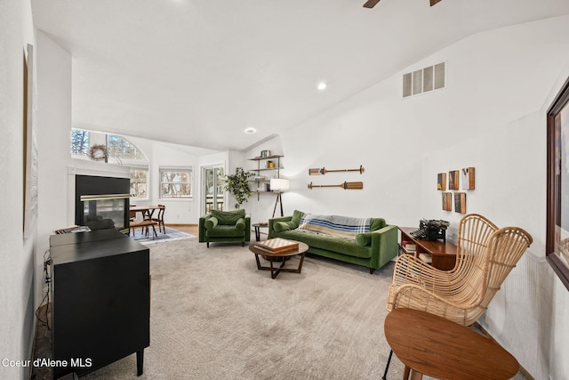 carpeted living room featuring lofted ceiling, ceiling fan, and a multi sided fireplace