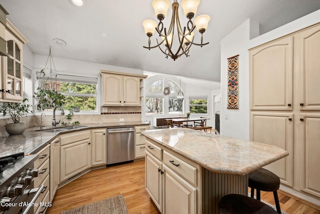 kitchen featuring sink, dishwasher, hanging light fixtures, a center island, and a kitchen bar