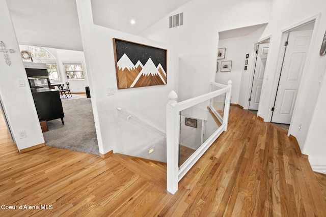 hall with hardwood / wood-style flooring and lofted ceiling