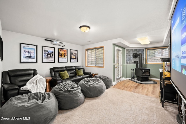 living room featuring carpet flooring and a wood stove