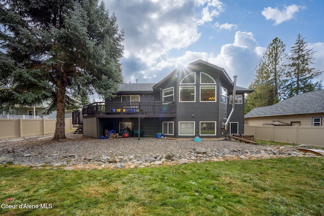 rear view of property with a wooden deck and a yard