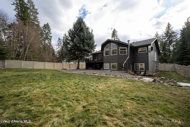 back of property featuring a wooden deck and a yard