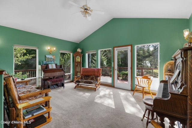 living area with ceiling fan, light colored carpet, and vaulted ceiling