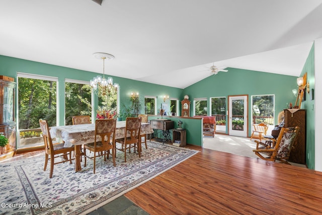 dining area featuring lofted ceiling, wood-type flooring, and ceiling fan with notable chandelier