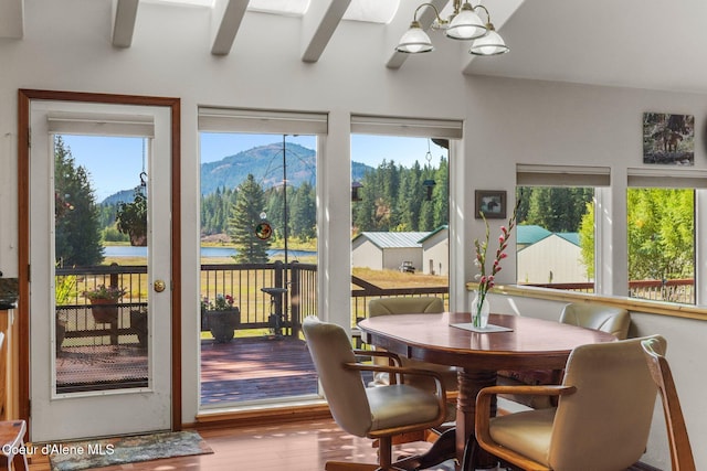 sunroom / solarium featuring a mountain view and a chandelier