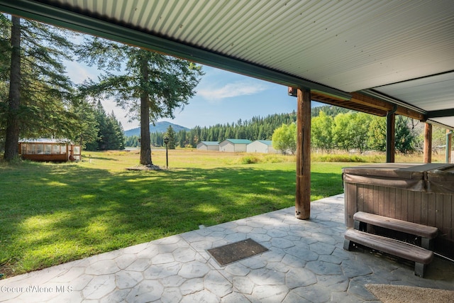 view of patio / terrace with a hot tub and a mountain view