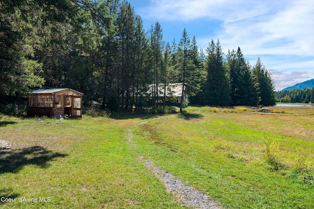 view of yard with a water view and an outdoor structure