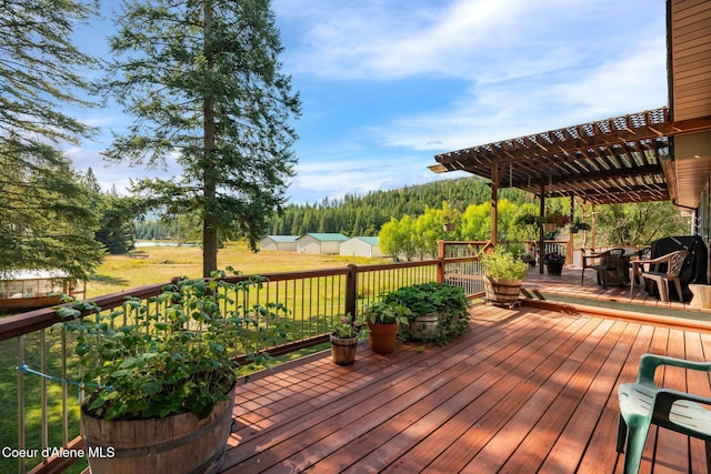 wooden terrace featuring a yard and a pergola