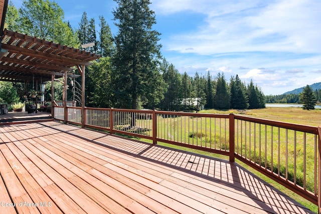 deck with a yard and a pergola