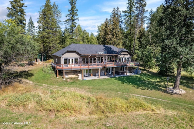 rear view of house featuring a wooden deck, a yard, and a patio area