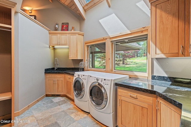 laundry room featuring washer and clothes dryer, sink, a skylight, and cabinets