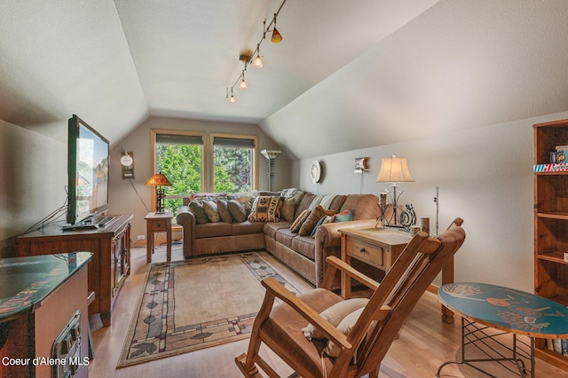 living room with lofted ceiling, light hardwood / wood-style flooring, and rail lighting