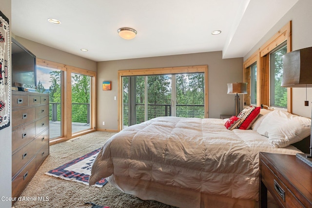 bedroom with carpet flooring, multiple windows, and access to outside