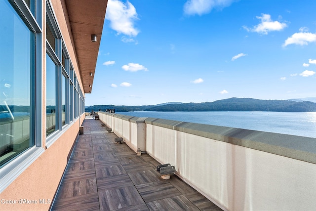 balcony featuring a water and mountain view