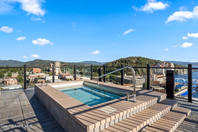 view of pool with an in ground hot tub and a mountain view