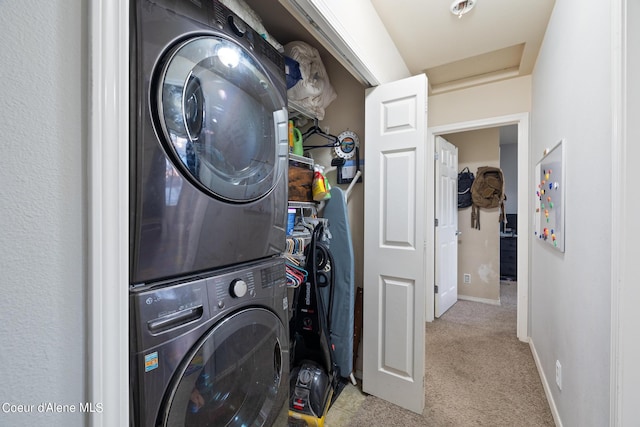 clothes washing area with light carpet and stacked washer / dryer