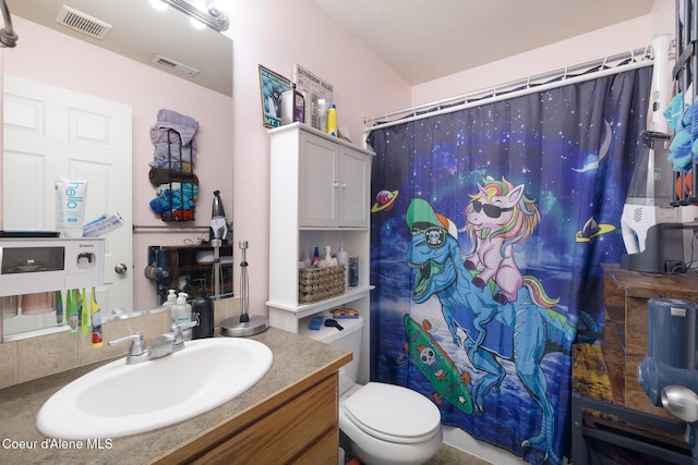 bathroom featuring vanity, toilet, and a shower with shower curtain