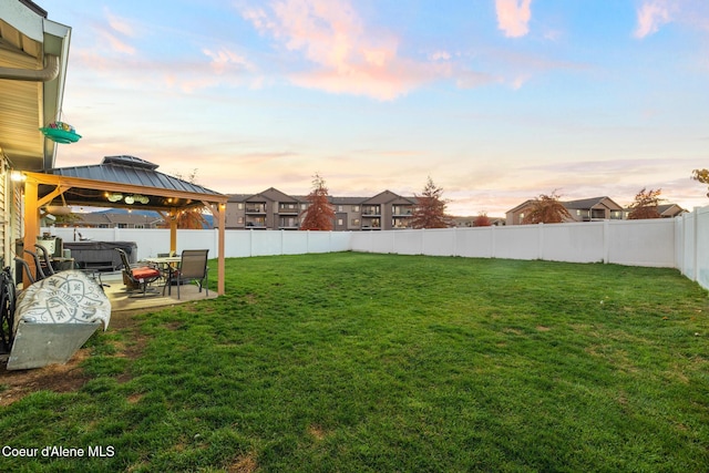 yard at dusk with a gazebo and a patio area