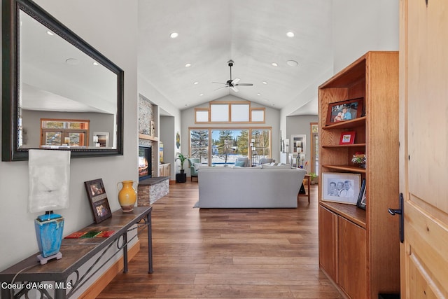 living room with hardwood / wood-style floors, a fireplace, high vaulted ceiling, and ceiling fan