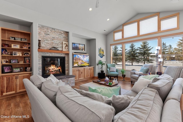 living room featuring hardwood / wood-style flooring, a fireplace, high vaulted ceiling, and built in features