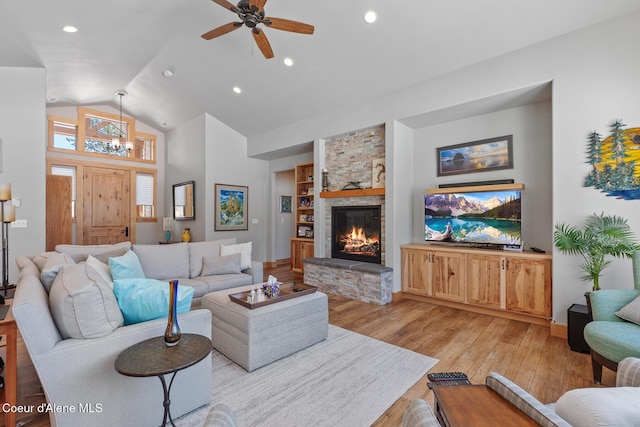 living room featuring built in features, ceiling fan, high vaulted ceiling, a stone fireplace, and light wood-type flooring