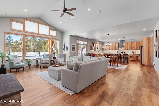 living room featuring ceiling fan, high vaulted ceiling, and light wood-type flooring