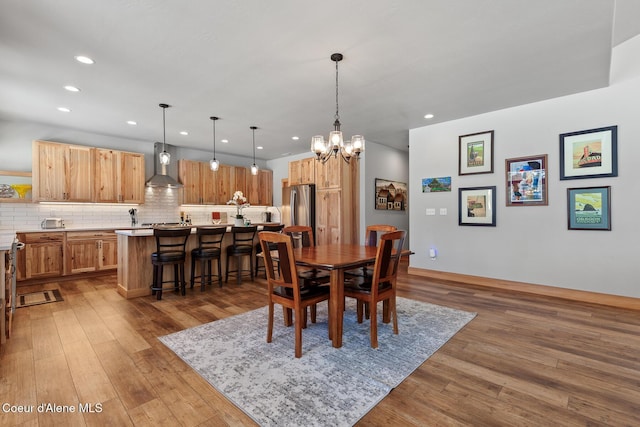 dining area with hardwood / wood-style floors and an inviting chandelier