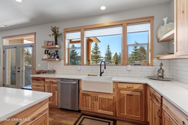 kitchen featuring hardwood / wood-style floors, sink, stainless steel dishwasher, and decorative backsplash