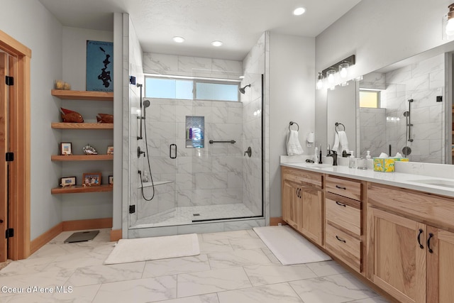 bathroom featuring a healthy amount of sunlight, a shower with shower door, and vanity