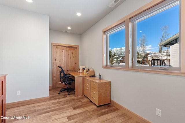 home office with light hardwood / wood-style flooring