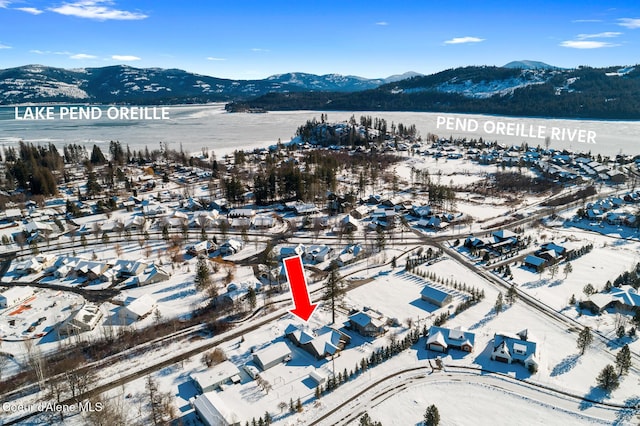 snowy aerial view with a water and mountain view