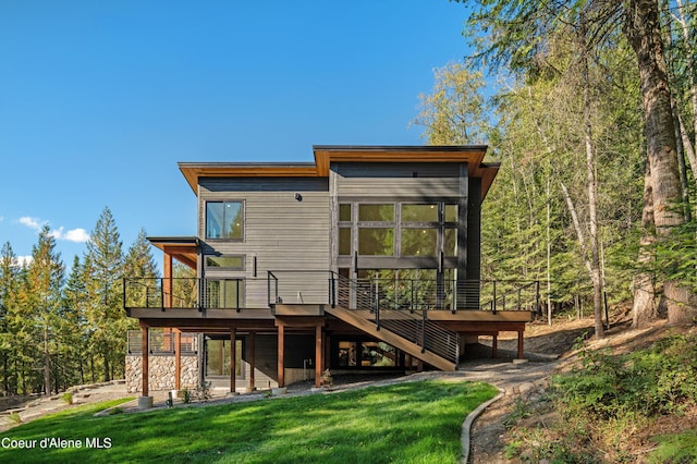 rear view of property featuring a yard and a deck