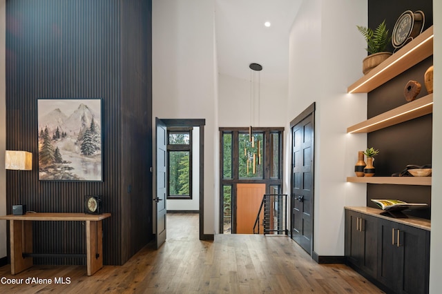 foyer entrance with hardwood / wood-style flooring and high vaulted ceiling