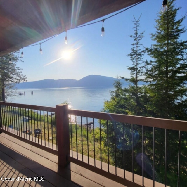 wooden deck with a water and mountain view