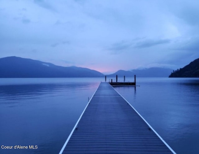 view of dock with a water and mountain view