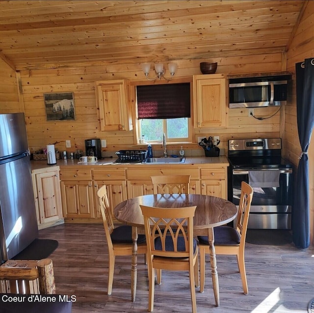 kitchen featuring appliances with stainless steel finishes, lofted ceiling, and light brown cabinetry