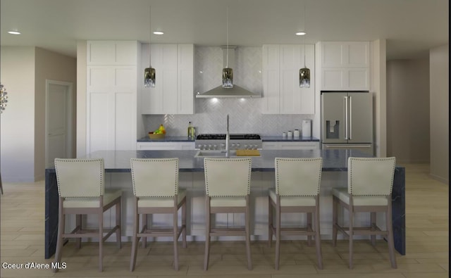 kitchen with a kitchen island with sink, tasteful backsplash, light wood-style floors, high quality fridge, and wall chimney exhaust hood