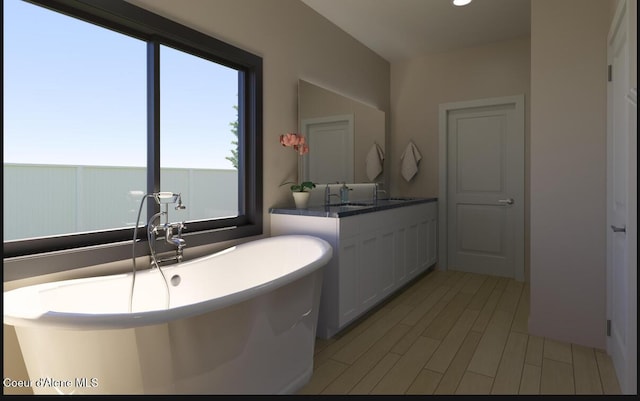 bathroom with a freestanding tub, vanity, and wood finished floors